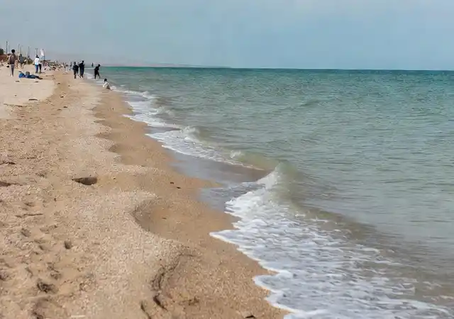 عکس واقعی از ساحل چمخاله با خط ساحلی آرام، آبهای دریای خزر و آسمان ابری معمول گیلان.